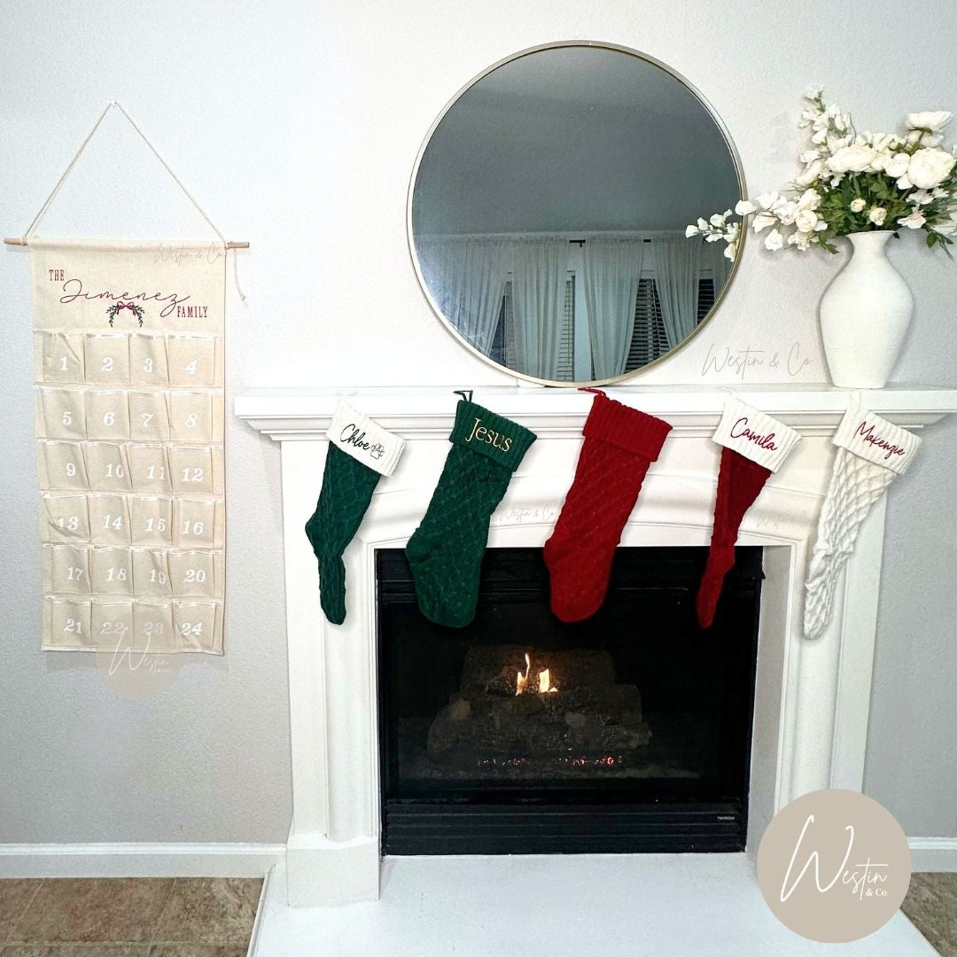 Merry Christmas advent calendar hanging beside a fireplace with stockings